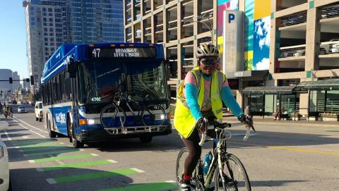 Bike rider and bus in downtown Kansas City