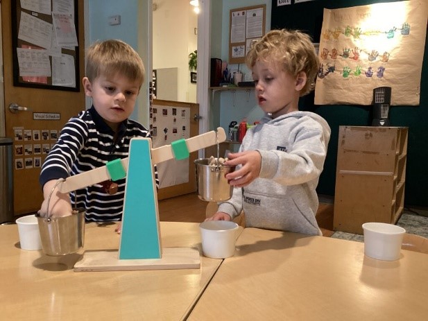 Two children play with measuring materials