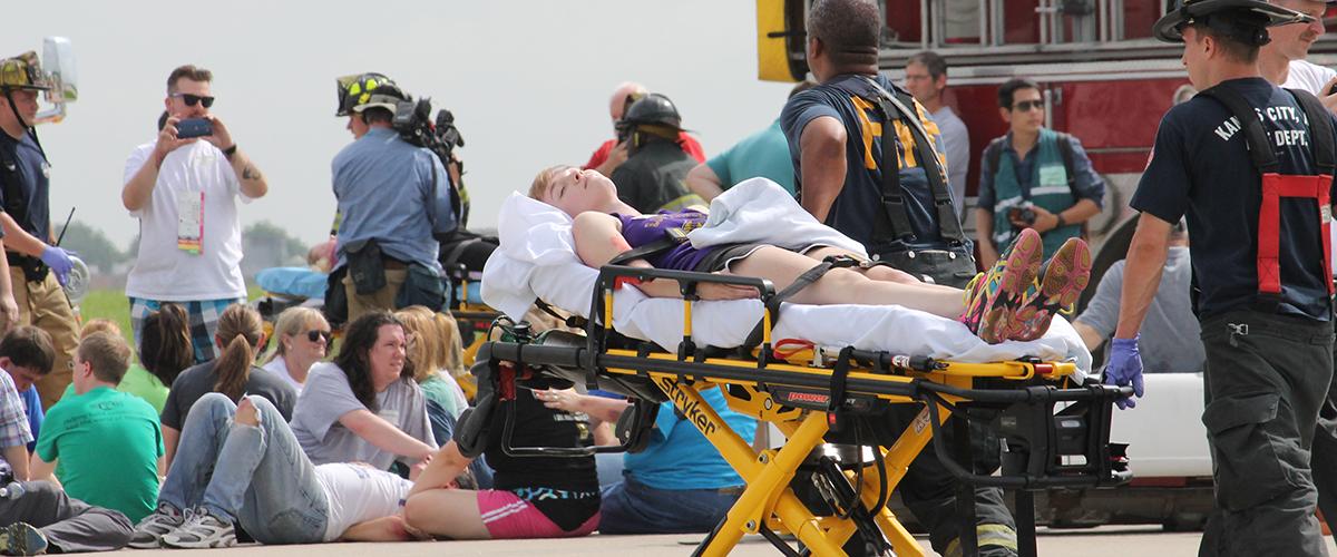 Complex coordinated attack training exercise with first responders assisting a victim on stretcher