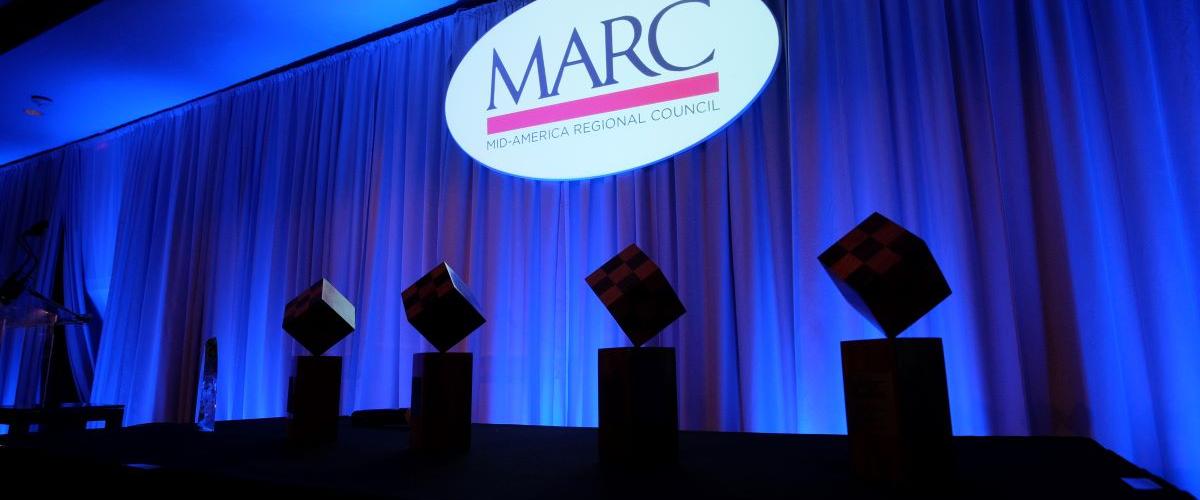 MARC logo projected on screen with awards in shadow foreground