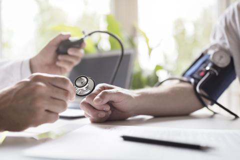 Health focus area photo, doctor taking someone's blood pressure