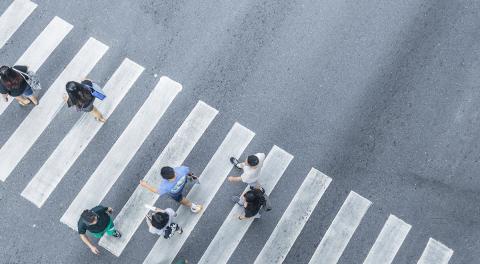 An aerial view of pedestrians walking in a crosswalk