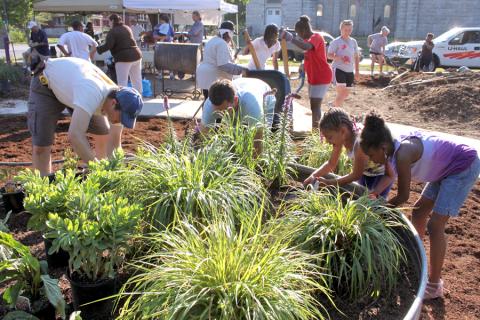 Volunteers tend to plants at the Benton Community Garden in Kansas City, Missouri