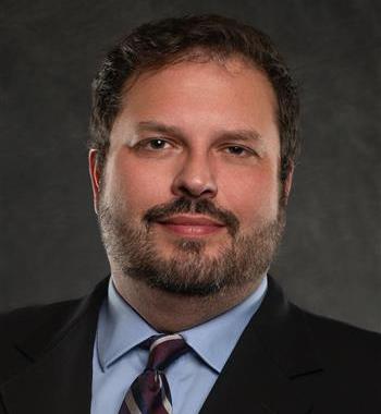 Headshot of Damien Boley in dark suit