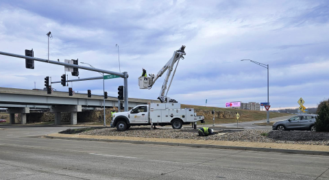 Bucket truck installing camera on traffic signal pole in an intersection