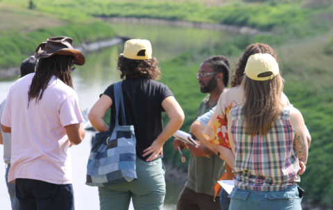 Local landscaping contractors look out upon the Blue River with tour guide from Heartland Conservation Alliance