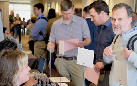 Attendees line up with professional development forms in hand at stormwater conference in 2023.