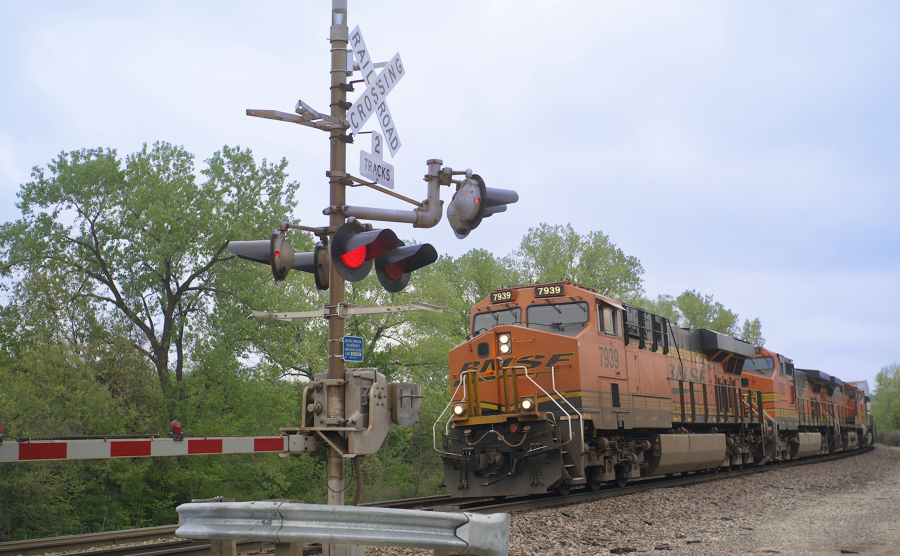 Train on railroad with crossing sign and signal