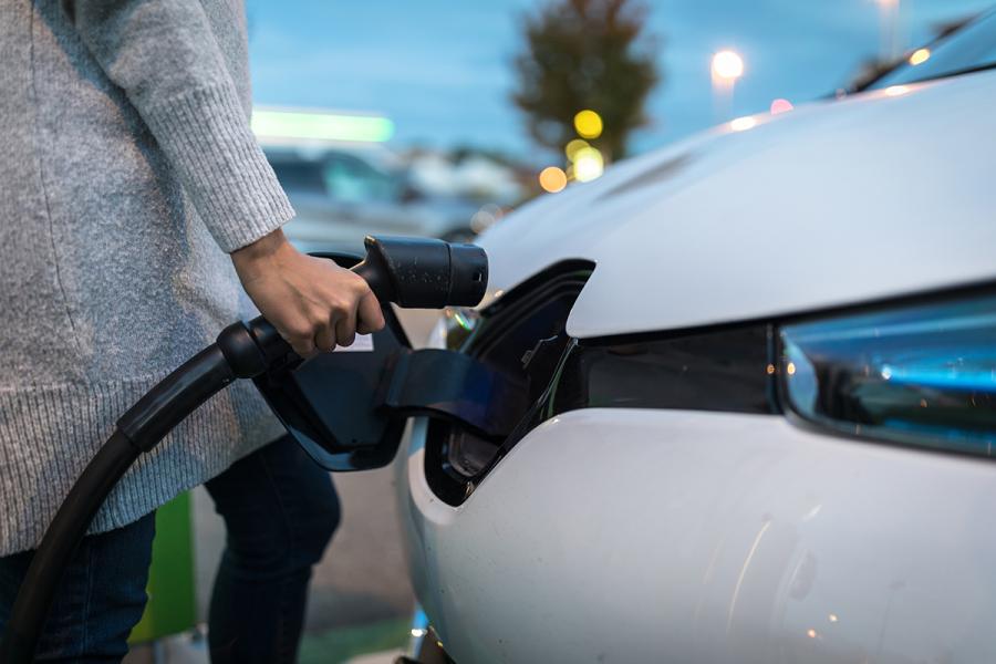 A person charging an electric vehicle