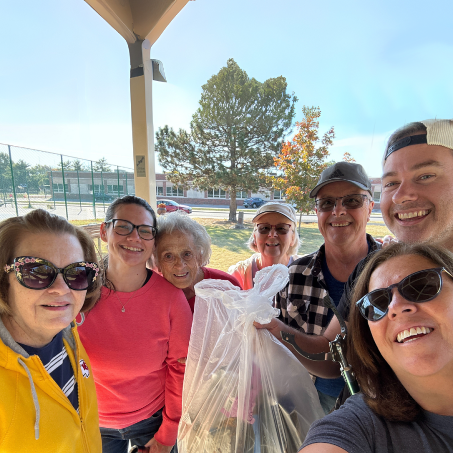 Volunteers pose for selfie with trash bag at Macken Park