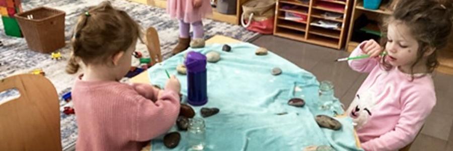 Two children paint rocks with water