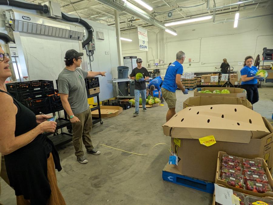 Warehouse floor space filled with pallets of food and volunteers